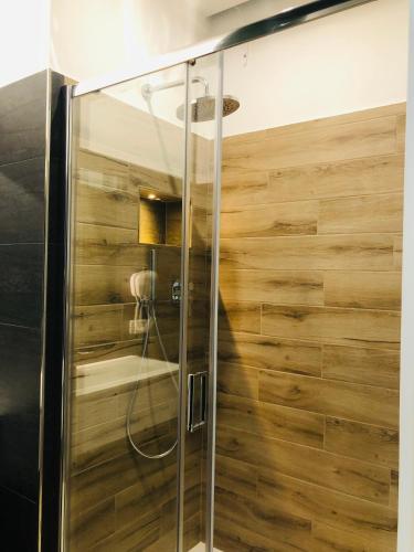 a shower in a bathroom with a wooden wall at Sesto Senso Home in Santa Maria del Cedro