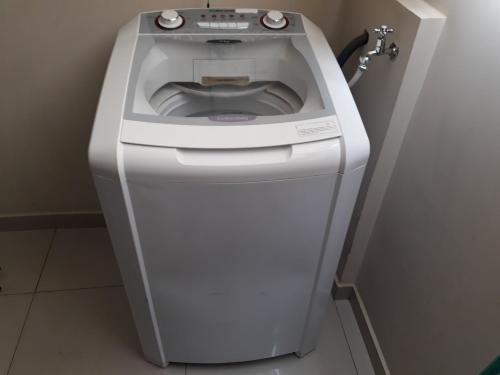 a washing machine sitting in a corner of a room at Apartamento Capitólio D'Loren dos lagos 4º andar in Capitólio