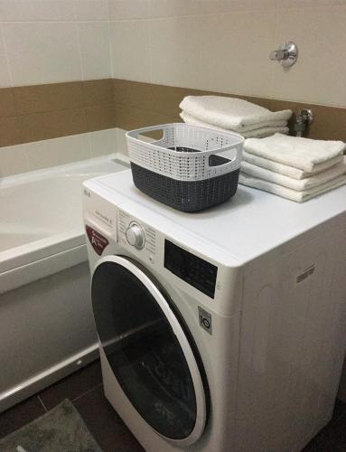 a washing machine with a basket on top of it in a bathroom at Apartman CITY CENTER 3-šetalište in Prijedor