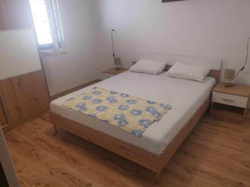 a bedroom with a bed with a blanket on it at VELI LOŠINJ Rovenska 52 in Veli Lošinj