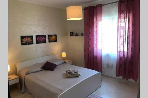 a bedroom with a large bed with purple curtains at Pizzo Beach Club, 11 G in Pizzo