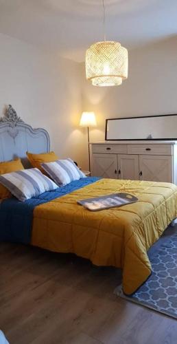 - une chambre avec un grand lit et une couverture jaune dans l'établissement Atelier 46, à Honfleur