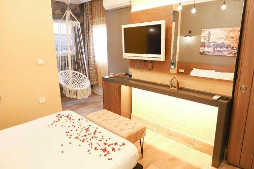 Habitación con cama, TV y espejo. en BetaS GuestHouse, en Antalya