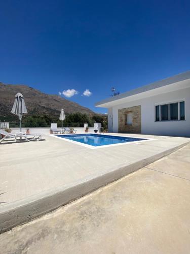 a swimming pool in front of a house at Maria Place in Triopetra