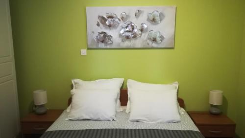 a bedroom with a bed with two pillows and a painting at Apartment Sunny Place in Pula