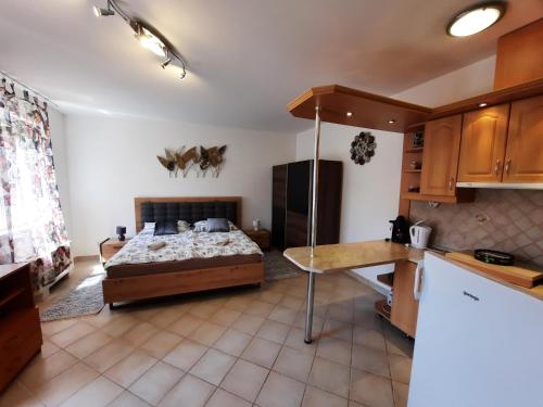 ハイドゥソボスローにあるCrazy Frog Gambrinusz II.のベッドルーム1室(ベッド1台付)、キッチンが備わるアパートメントです。