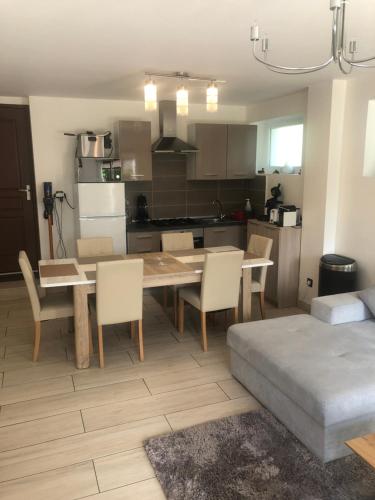 cocina y comedor con mesa y sillas en Logement au calme dans une maison., en Moirans-en-Montagne