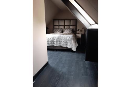 a bedroom with a bed and a wooden floor at Zomerhuis Adriana in Egmond aan Zee