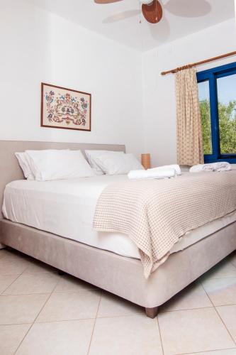 a bed in a white room with a window at Kanellis Studios in Avlemonas