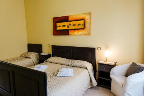 a bedroom with two beds and a painting on the wall at b&b Antiche Dimore Taurasi in Taurasi