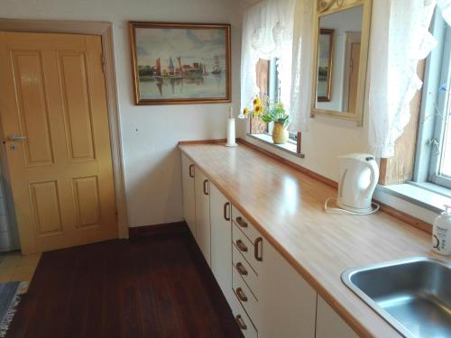 a kitchen with a sink and a wooden counter top at Holtens Gaard in Hobro