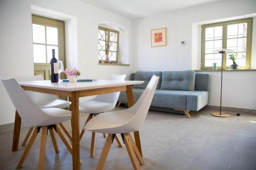 a living room with a table and white chairs at Hiša Liza in Kobarid