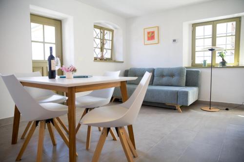 ein Wohnzimmer mit einem Tisch und weißen Stühlen in der Unterkunft Hiša Liza in Kobarid