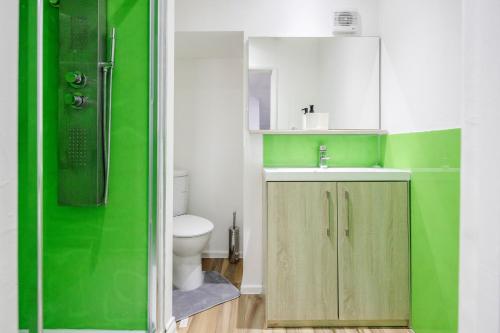 ein grünes Bad mit einem Waschbecken und einem WC in der Unterkunft TMS Spacious 4 bedroom house! Free Parking! Crosby Dagenham! in Dagenham