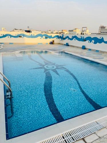 a swimming pool with a reflection of a woman in the water at Green House Hotel Suites & Apartment in Dubai