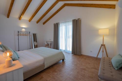 a bedroom with a large bed and a window at Ares do Monte - Turismo Rural in Cercal