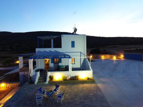a white house with chairs and lights in front of it at Villa Aspa Paros in Dhragoulás