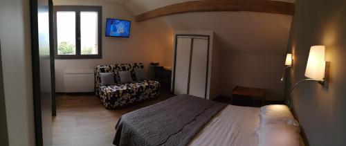 a bedroom with a bed and a chair and a window at Le Grand Chatelard HÔTEL BAR RESTAURANT in Sainte-Marie-de-Cuines