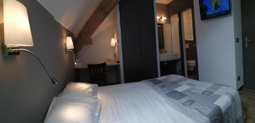 a hotel room with a bed and a lamp at Le Grand Chatelard HÔTEL BAR RESTAURANT in Sainte-Marie-de-Cuines