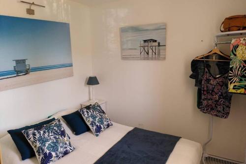 - une chambre avec un lit avec des oreillers et une jetée dans l'établissement Nid douillet F2, clim, jardin, piscine, parking, plage 200 m Palavas, à Palavas-les-Flots