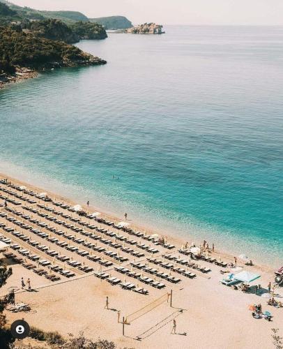 a beach with a bunch of chairs and the water at Apartmani Prelević in Kamenovo