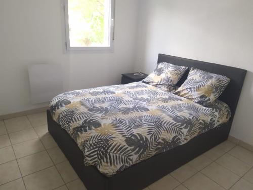 - un lit dans une chambre avec une couette noire et blanche dans l'établissement Résidence calme avec piscine, à Béziers