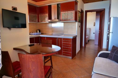 a kitchen with a table and a kitchen with a tv at Villa Crystal in Sarandë