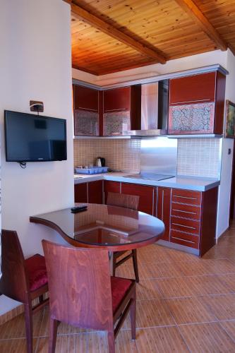 a kitchen with a table and some chairs and a counter at Villa Crystal in Sarandë
