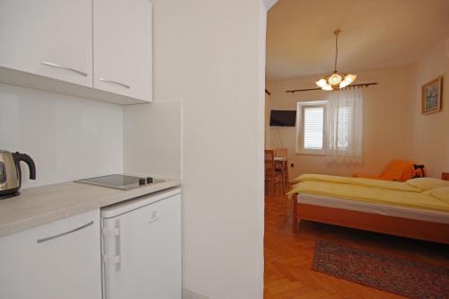 a kitchen and a living room with a bed at Apartmani Srzic in Makarska