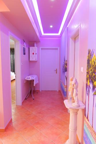 a hallway with purple walls and a white door at Villa Crystal in Sarandë