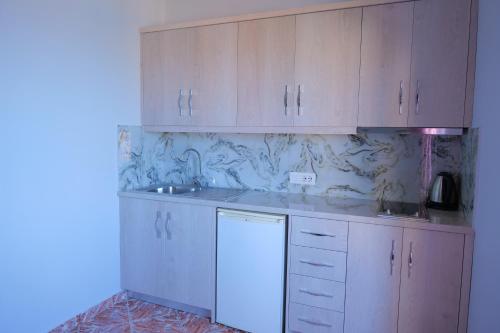 a kitchen with white cabinets and a sink at Villa Crystal in Sarandë