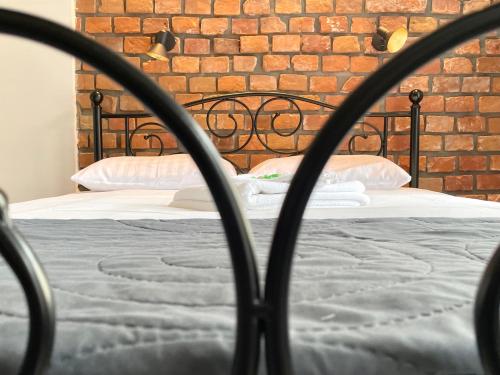 a bedroom with a bed with a brick wall at Copernicus Street Apartment - Broken Flowers and Twin Peaks in Toruń
