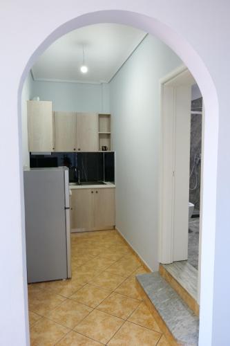 an empty kitchen with a refrigerator and an archway at Villa Crystal in Sarandë