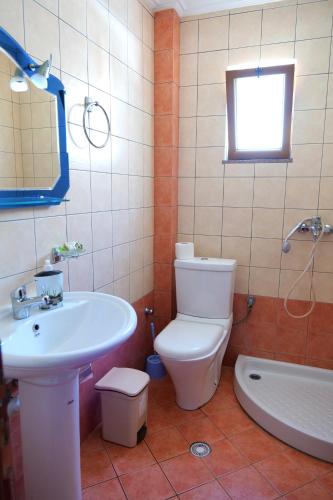 a bathroom with a toilet and a sink and a tub at Villa Crystal in Sarandë
