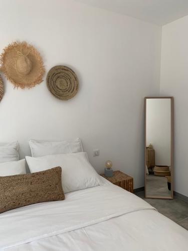 a bedroom with a white bed and a mirror at Le Cabanon de Val in Gassin