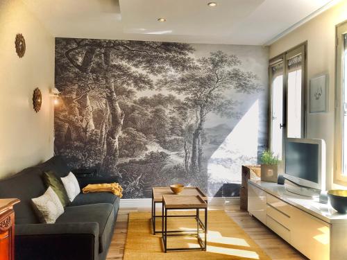 un soggiorno con divano e murale di RétroMirabeau "Le Raspaïl" - 65m2 avec VUE - 2 CHAMBRES - 4 pers - COURS MIRABEAU HALLES GARE - EMPLACEMENT TOP - Chèques Vacances CONNECT a Narbonne