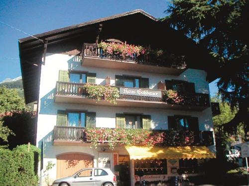 a building with flowers on the balconies and a car at Haus Gassbauer in Schenna