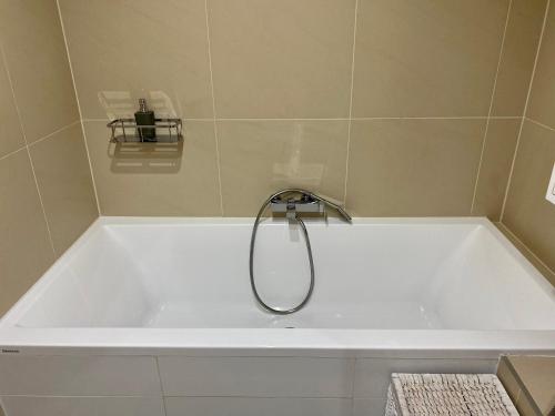 a white bath tub with a shower in a bathroom at Luxury apartman Bojnice in Bojnice