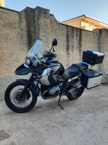 a black motorcycle parked next to a wall at B&B Centrale in Tortolì