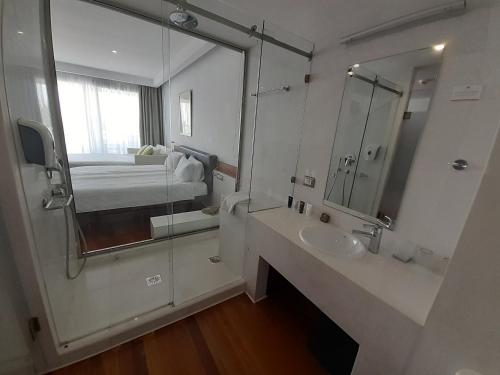 a bathroom with a mirror and a sink and a bed at Buca Beachclub Resort in Messini