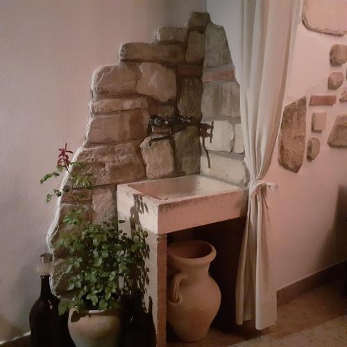 a stone fireplace in a room with some plants at B&B Borgo Cortese in Gavi