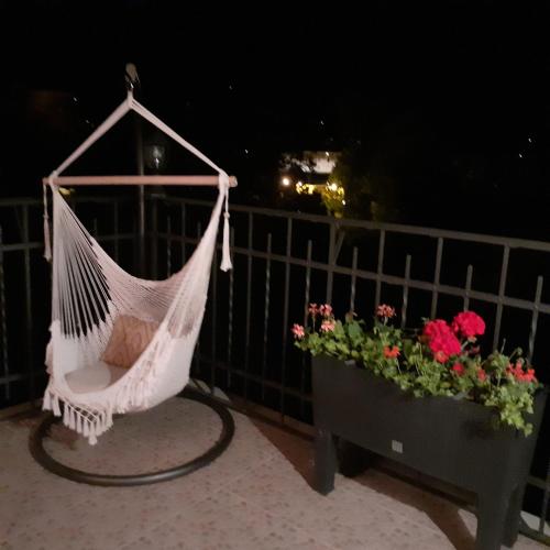a hammock hanging on a balcony with flowers at B&B Borgo Cortese in Gavi