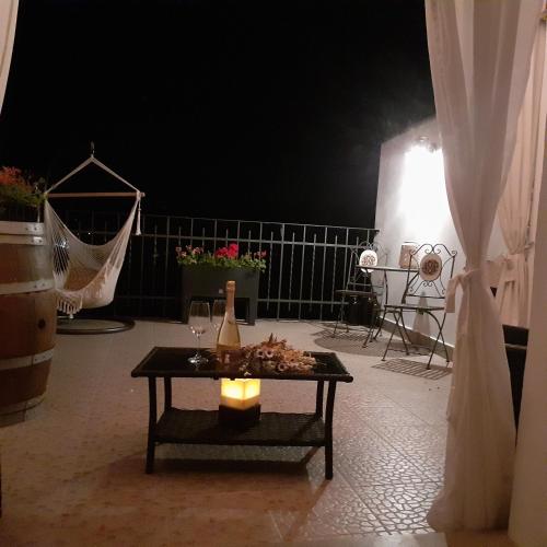 a table with a bottle and a candle on a patio at B&B Borgo Cortese in Gavi