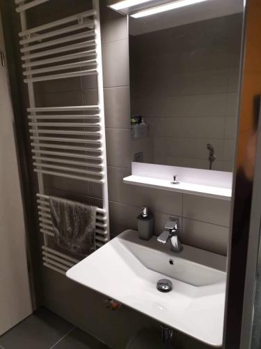 a bathroom with a white sink and a mirror at MANDARA WELLNES APARTMANOK in Siófok