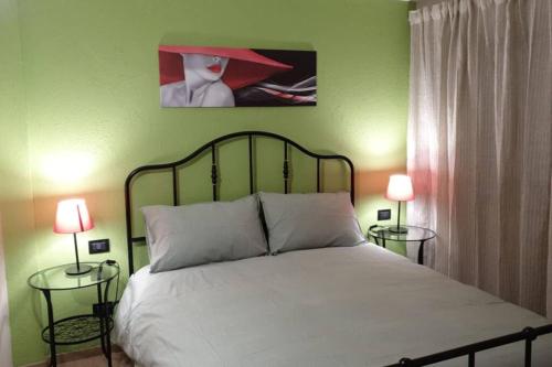 um quarto com uma cama com dois candeeiros e uma imagem na parede em Ad un passo dal centro em Aosta