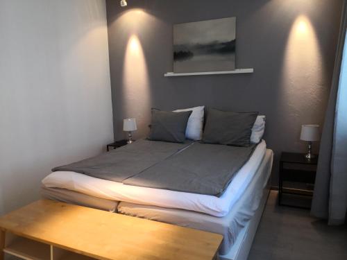 a bed in a room with two lamps and a table at Central Tammela 80m2 in Tampere