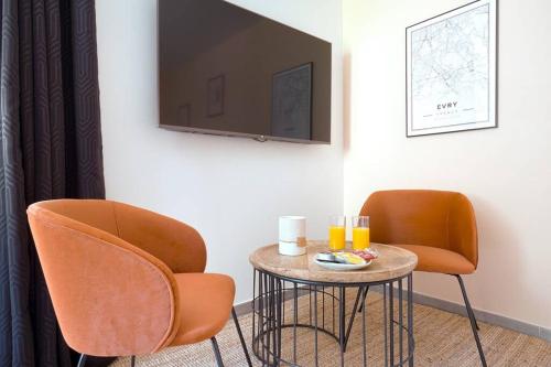 een kamer met 2 stoelen en een tafel met drankjes erop bij Studio de charme - calme, discret & cosy - 3' RER in Évry-les-Châteaux