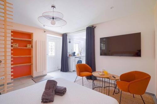 een slaapkamer met een bed en een tafel en stoelen bij Studio de charme - calme, discret & cosy - 3' RER in Évry-les-Châteaux