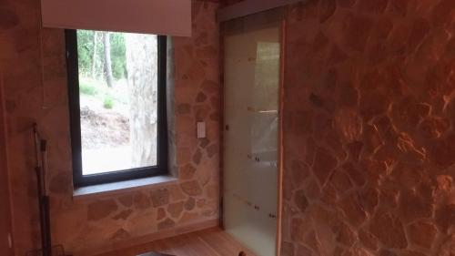 a bathroom with a window and a stone wall at Quinta dos Mangues in São Martinho do Porto