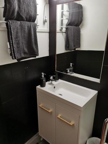 een badkamer met een witte wastafel en een spiegel bij chambres randonneurs in Plestin-les-Grèves